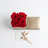 Cajas de rosas La Mini Dorada RED de BELLE FLEUR ECUADOR, con elegantes pomos en una sesión de fotos.